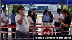 Люди в защитных масках у центра тестирования на коронавирус. Алматы, 8 июля 2020 года.