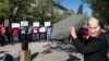 Человек в маске Путина с макетом бомбы перед российским посольством в Берлине во время демонстрации против действий России в Сирии 