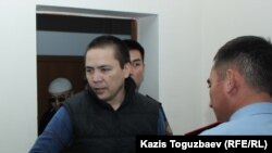 Алмата Жумагулова конвой заводит в зал суда во время рассмотрения дела «джихадистов». Алматы, 26 сентября 2018 года.