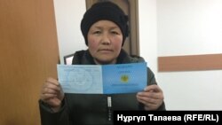 Сайрагүл Сауытбай мерзімі ұзартылған "пана іздеуші тұлға" куәлігін көрсетіп тұр. Алматы, 28 қаңтар 2019 жыл.
