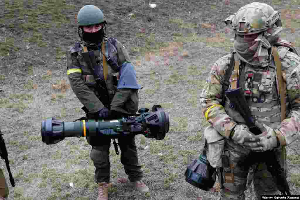 Membri ai Forțelor de apărare teritorială ucrainene țin în mână arme antitanc NLAW la un punct de control din Kiev, pe 6 martie.