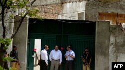 Pakistanyň howpsuzlyk işgärleri “Al-Kaýda” terror toparynyň lideri Osama bin Ladeniň gizlenen jaýynyň ýanynda, Abbottabat, 2011-nji ýylyň 4-nji maýy.