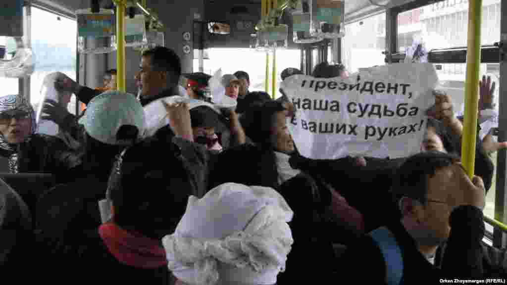 Активист движения «ипотечников» развернул в автобусе плакат "Президент, наша судьба в ваших руках!". Астана, 22 мая 2013 года.