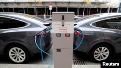 Makina elektrike të kompanisë Tesla, duke rimbushur bateritë në Berlin.