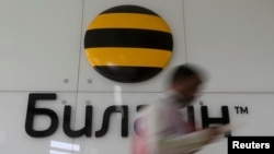 Russia -- A man walks past the company logo in the head office of Beeline, a brand owned by telecoms group Vimpelcom, in Moscow, August 7, 2013