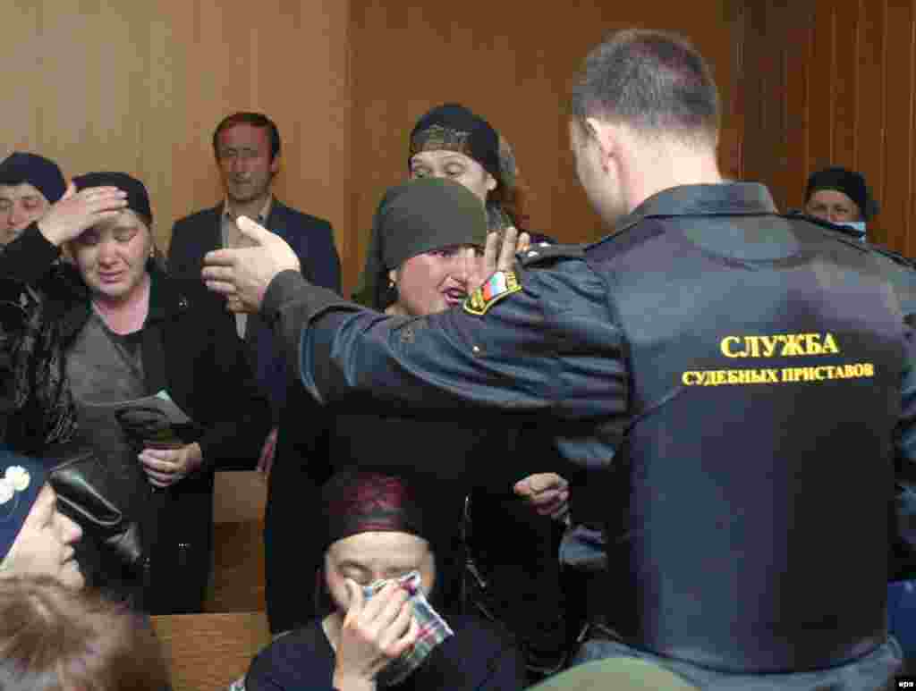 Një përmbarues përpiqet t'i qetësojë gratë, gjatë gjykimit të Nurpashij Kulayevit, i vetmi militant i arrestuar gjatë krizës së pengjeve të Beslanit, në një gjykatë në Vladikavkaz, më 19 maj 2005.