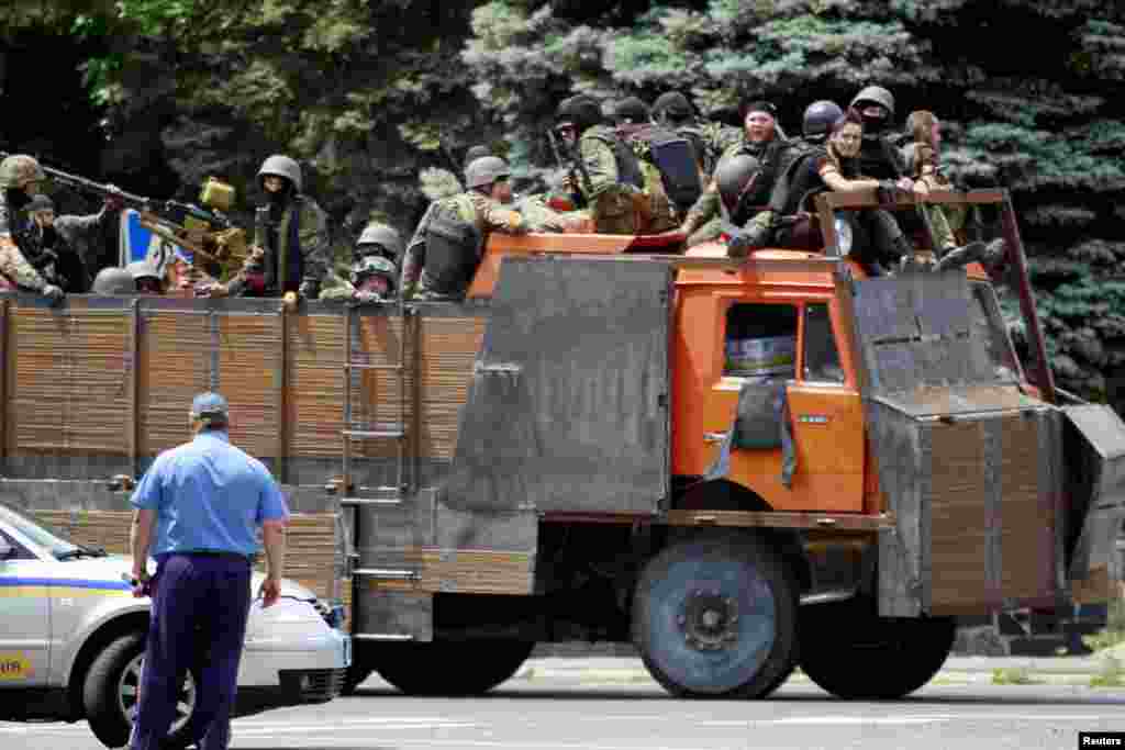Українські силовики на вантажівці у Маріуполі, який був звільнений 13 червня від бойовиків угруповання «ДНР», котре в Україні визнане на офіційному рівні терористичною організацією