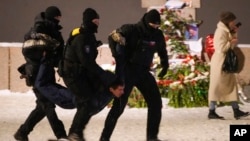 Ofițeri de poliție rețin un bărbat după ce acesta a depus flori la Memorialul victimelor represiunilor politice din Sankt Petersburg, pe 16 februarie.