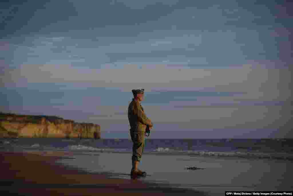 Honorable Mention, General News: A man dressed in a World War II-era U.S. uniform pays his respects to those who died in the D-Day landings in Normandy, France, on June 6, 2014, the 70th anniversary of the Allied invasion. (Denik/Martin Divisek) 