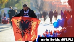 Një shitës mban në duar flamurin e Shqipërisë. Prishtinë, 28 nëntor 2020. 