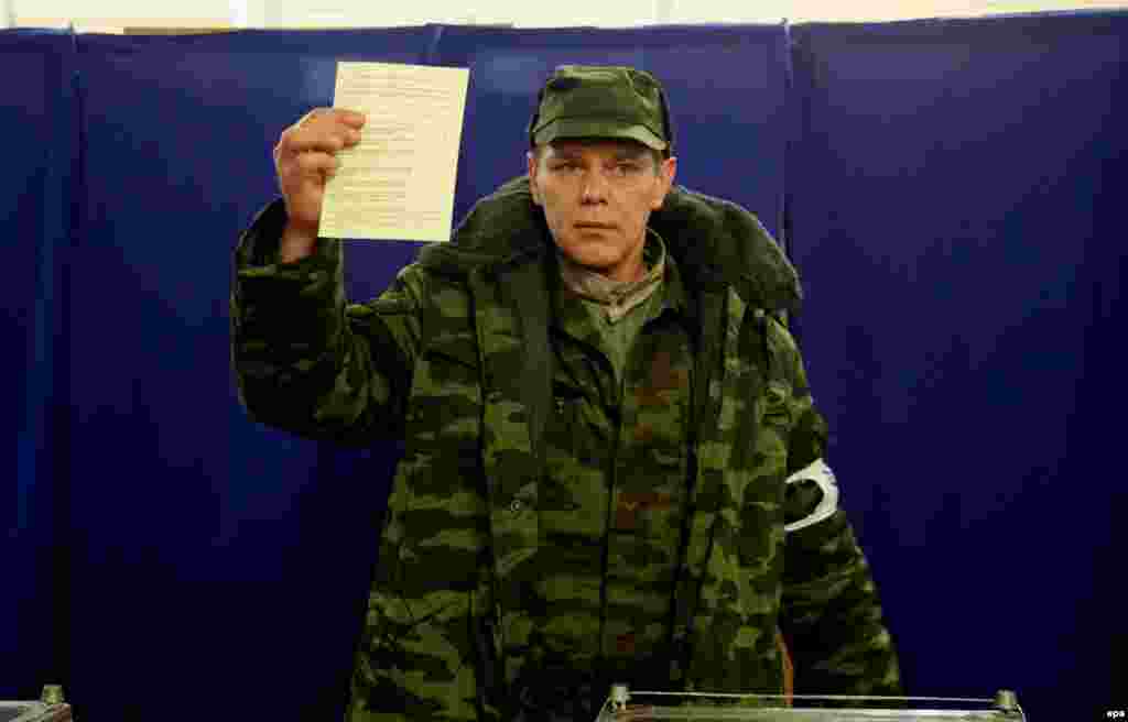 Ресейшіл "Қырымның өзін өзі қорғау тобының" мүшесі өзі дауыс берген бюллетеньдегі "Ресей құрамына қосылуды жақтаймын" деген тұсқа қойылған белгіні журналистерге көрсетіп тұр. 