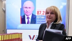 Russian Central Election Commission chief Ella Pamfilova walks past a screen displaying a portrait of President Vladimir Putin following the announcement of the official results in a three-day presidential election in Moscow on March 21.