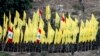 Pjesëtarë të grupit Hezbollah duke dëgjuar fjalimin e udhëheqësit të tyre në Liban. Gusht 2015.