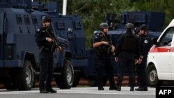 Kosovo's police officers stand guard at the entrance to the village of Banjska after one policeman was killed and another wounded in north Kosovo on September 24.