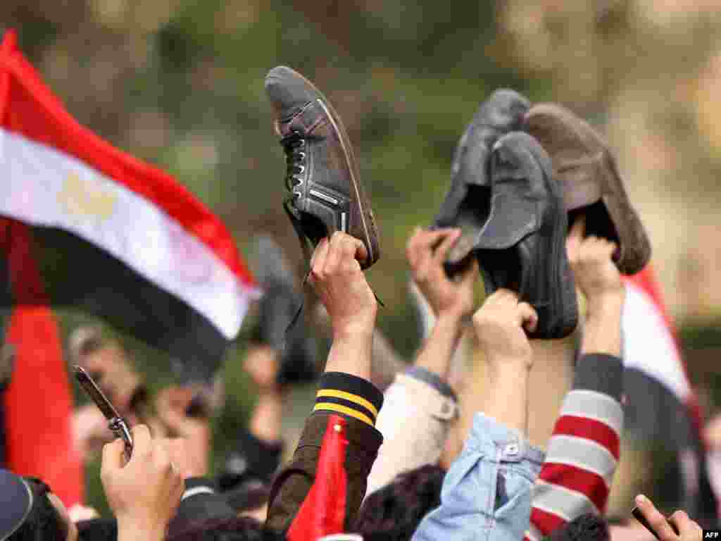 مخالفان کفشهای خود را در مخالفت با روش تلویزیون دولتی مصر بر سر دست بردهاند