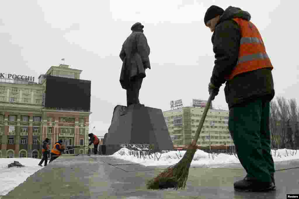 Працівники комунальних служб вичищають наслідки вибуху біля пам'ятника Леніну у Донецьку. Внаслідок вибуху, що стався близько четвертої ранку 27 січня, була пошкоджена частина постаменту