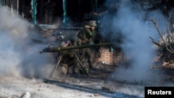 În Bahmut, estul Ucrainei, un militar ucrainean lansează o grenadă anti-tank înspre forțele ruse. În ciuda atacurilor masive, a implicării mercenarilor Wagner și a distrugerii aproape totale, orașul nu a fost încă revendicat de forțele ruse. Imagine din 13 februarie 2023.