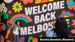 HEALTH-CORONAVIRUS/AUSTRALIA
People take photos in front of a 'Welcome Back' sign in Melbourne, October 28, 2020. 