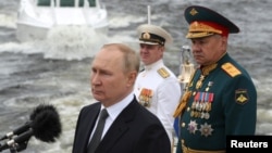 Russian President Vladimir Putin (left) and Defense Minister Sergei Shoigu attend Navy Day celebrations in St. Petersburg on July 31.