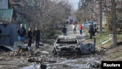 Banorët e Dnipros inspektojnë pasojat e një sulmi rus në qytetin ukrainas natën e 28 marsit.