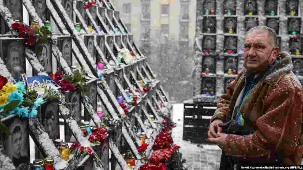 Еден човек пали свеќа во Киев, Украина, на 18 февруари, на споменикот во чест на „Небесната стотка“, 104-те луѓе убиени од безбедносните сили за време на антивладините протести во 2014 година.