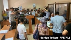 "Қаржы жымқыру" бабымен күдікке ілінген Қайырлы Омардың жақтастары сот залында белсенділерге қолдау көрсетіп тұр. Нұр-Сұлтан, 31 шілде 2019 жыл.