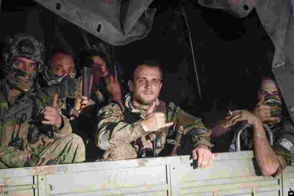 Membrii companiei militare Wagner stau în vehiculul lor pe o stradă din Rostov-pe-Don. 