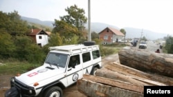 Vozilo KFOR-a porazi pored pomaknutih balvana na barikadi u selu Zupče, 27. oktobar 2011.