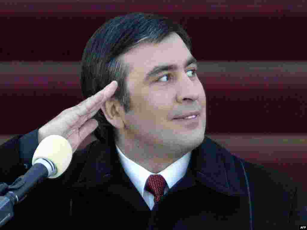 Președintele Mikheil Saakashvili salutînd în timp ce privea o paradă militară la Tbilisi, la 25 ianuarie 2004. La data la care a depus jurămîntul de președinte, la 37 de ani, Saakashvili a devenid cel mai tînăr șef de stat al Europei.