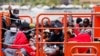 Migránsok a spanyol parti őrség hajója fedélzetén a Kanári-szigetek Arguineguín kikötőjében 2023. június 3-án