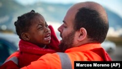 An de an, tot mai mulți africani încearcă să ajungă pe coastele Spaniei, fugind de sărăcie, criminalitate sau război. În imagine: un membru al serviciului de salvare maritimă și un copil salvat dintr-o barcă, aproape de Gibraltar, în 2018.