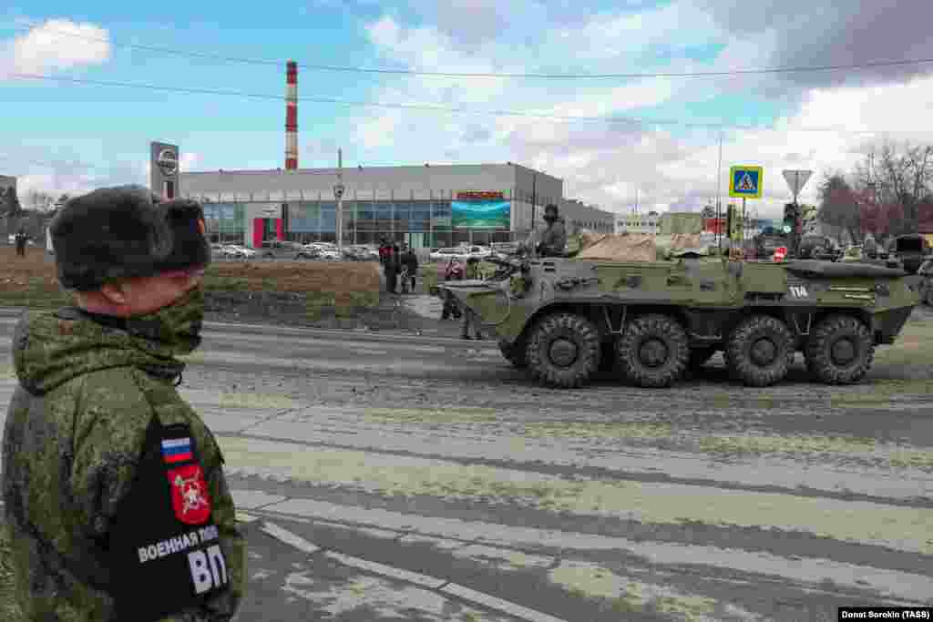Маскиран војник гледа како поминува пешадиско возило од типот БМП-3.