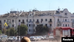 Autospeciale de pompieri și mașini de poliție ajung la locul unui atac cu rachete rusești în Cernihiv, Ucraina, pe 19 august.