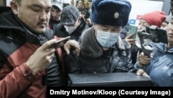 Милиция кызматкери Temirov LIVE долбоорунун кеңсесиндеги компьютерлерди конфискациялап жаткан учур. Булак: Дмитрий Мотинов / Kloop