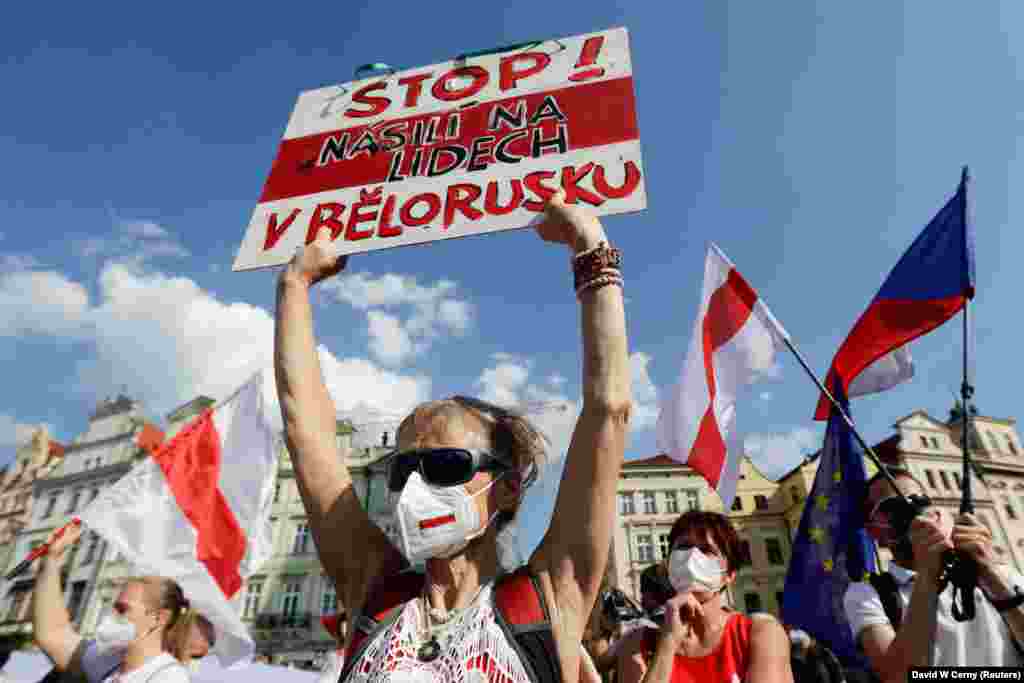 Учасниця акції тримає в руках плакат із написом чеською мовою: «Припиніть насильство над людьми у Білорусі»