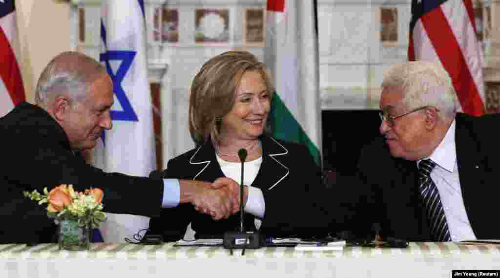 A kép 2010. szeptember 2-án készült Washingtonban Netanjáhúról, aki épp kezet ráz Mahmúd Abbász palesztin elnökkel, Hillary Clinton akkori amerikai külügyminiszter társaságában. 