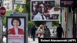 Njerëzit kalojnë pranë bilbordeve të dy kandidatëve për president të Maqedonisë së Veriut, Stevo Pendarovskit dhe Gordana Siljanovska-Davkova. Shkup, 18 prill, 2019.