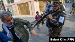 Një pjesëtar i forcave speciale talibane shtyn një gazetar (majtas) që po mbulonte një demonstratë nga gra protestuese jashtë një shkolle në Kabul, 30 shtator 2021.