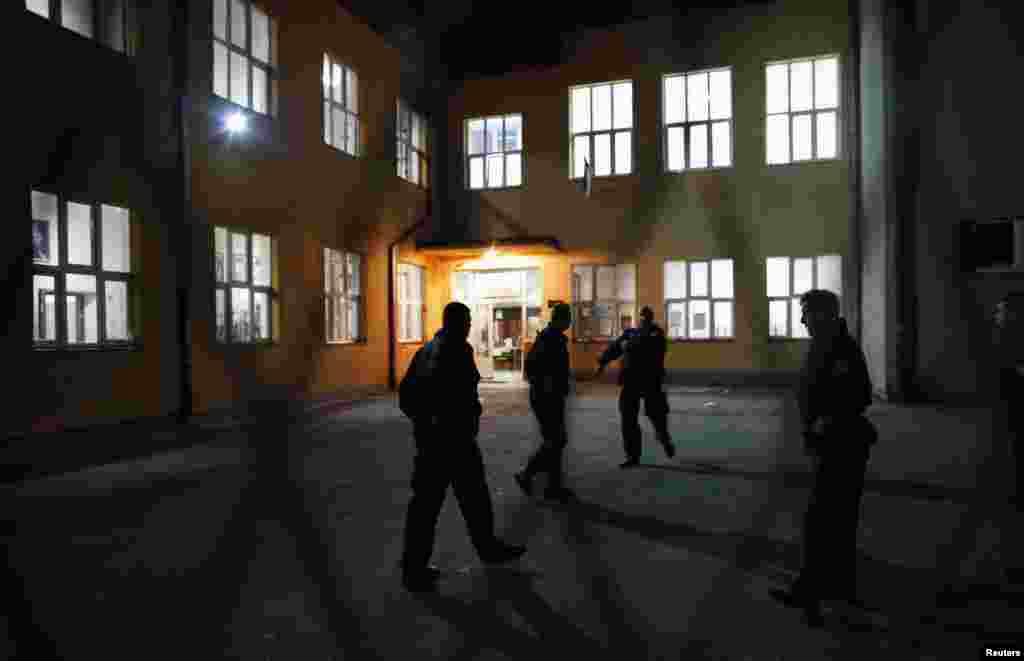 Косовската полиција пред изборно место во училиштето „Свети Сава“ во Митровица.