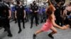 O protestatară dansează în vreme ce poliția încearcă să împiedice activiștii pentru drepturile LGBT să se adune pentru o paradă Gay Pride, interzisă de autoritățile locale, în centrul Istanbulului, Turcia, 26 iunie 2021. 