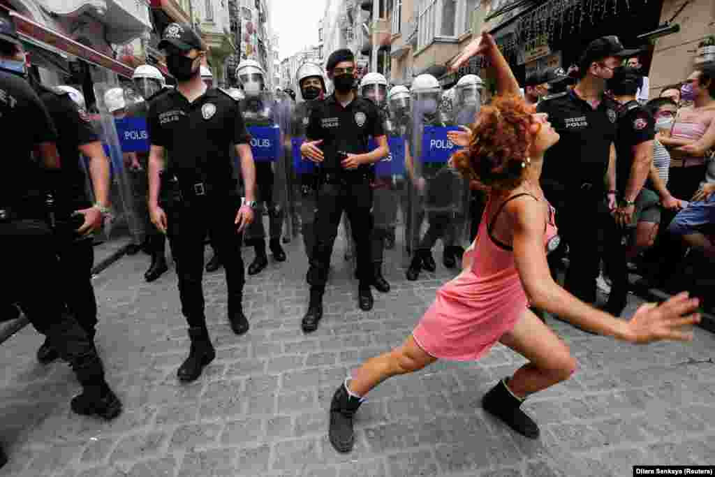Një protestuese vallëzon para policisë, që u mundua të pengonte aktivistët për të drejtat e komunitetit LGBT të mbanin paradë në Stamboll të Turqisë më 26 qershor, 2021.