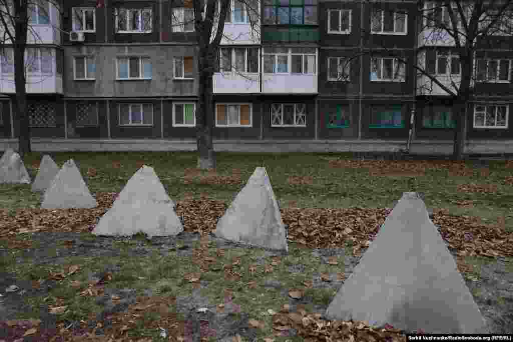 «Противотанковые заграждения «Зубы дракона» в Покровске. Светлана Ярославовна говорит, что поставщики приезжают в магазин каждый будний день, но некоторые водители боятся заезжать в центр города. «Мы встречаем их за мостом и передаем продукты, а затем сами их привозим». Если российские войска продолжат приближаться, говорит продавец, «я закрою магазин и сбегу с собаками и кошками, за которыми я здесь присматриваю. Я точно не буду жить здесь под властью России, если фронт приблизится. Но пока я буду здесь так долго, как смогу» 