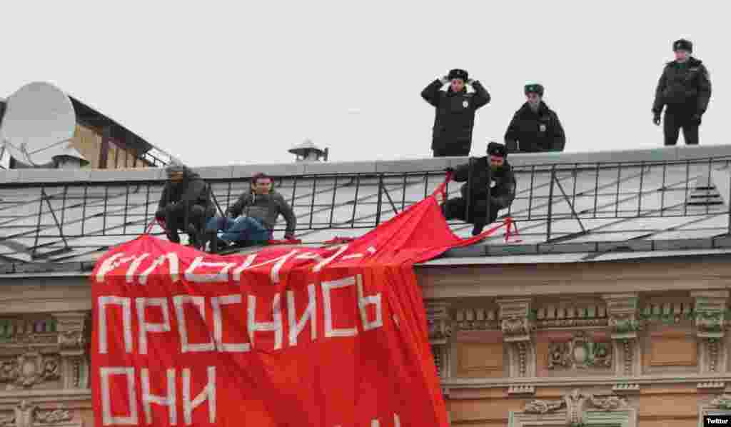 Poliția încearcă să-i scoată de pe un acoperiș, la Sankt Petersburg, pe activiștii mișcării de opoziție „O altă Rusie”, care au desfășurat o pancartă cu inscripția „Ridică-te, Ilici, și vezi-ți fiii!”, 4 noiembrie. Poliția a reținut, în total, 23 de oameni.