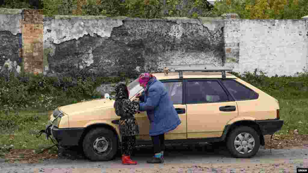 Эвакуация кезінде немересімен тұрған егде әйел 