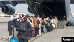 Disa afganë duke hyrë në një aeroplan amerikan gjatë procesit të evakuimit nga Kabuli më 18 gusht 2021. 