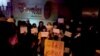 Një grup protestuesish duke kujtuar viktimat që vdiqë nga zjarri në Urumqi të Kinës.