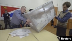 Членовите на изборната комисија ја празнат кутијата со гласачки ливчиња
