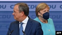 A Kereszténydemokrata Unió (CDU) vezetője, Armin Laschet kancellárjelölt és Angela Merkel német kancellár megérkezik a CDU székházába a választási éjszakán 2021. szeptember 26 -án Berlinben. (Fotó: John MACDOUGALL / AFP)
