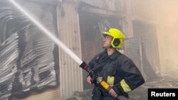Un pompier stinge incendiile de la silozurile cu cereale lovite de rachetele și dronele rusești, Odesa, 19 iulie. 