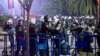 Протестиращ е притиснат от полицаи в оградата около кметството в Истанбул, 23 март 2025 г.